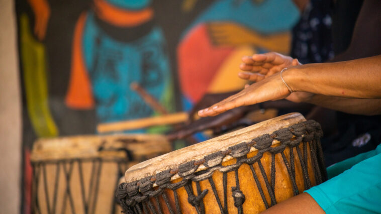 Close-up of hands playing djembe drums
